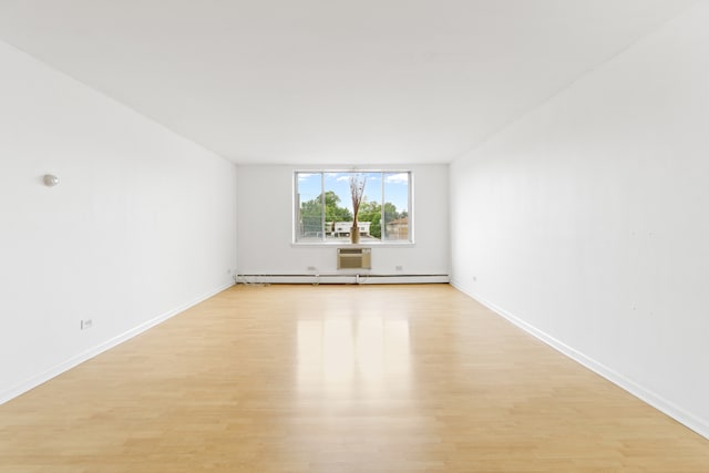 empty room featuring light wood-type flooring and baseboard heating