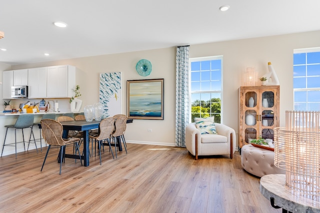 dining area with light wood-type flooring and a wealth of natural light