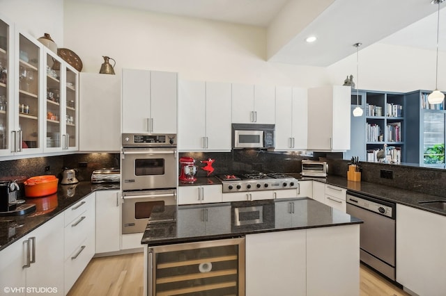 kitchen featuring appliances with stainless steel finishes, pendant lighting, white cabinetry, wine cooler, and a center island