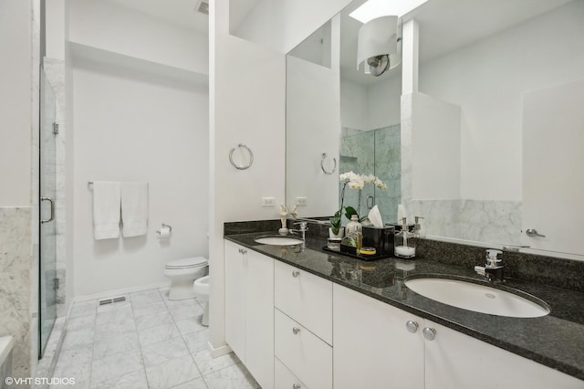 bathroom featuring a bidet, vanity, a shower with shower door, and toilet