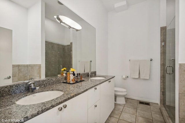 bathroom with an enclosed shower, vanity, tile patterned floors, and toilet