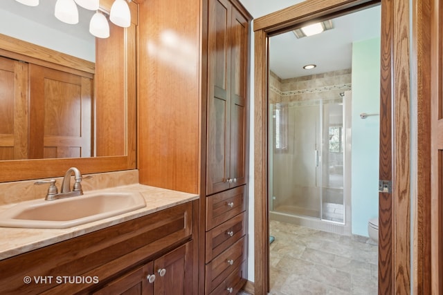 bathroom with tile patterned floors, vanity, toilet, and walk in shower