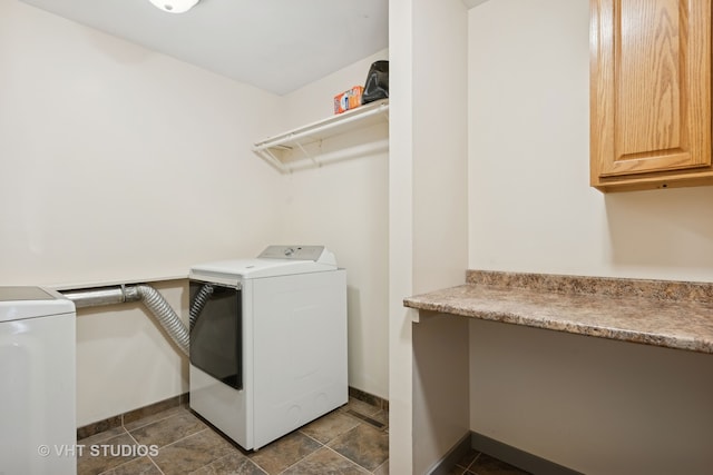 clothes washing area featuring washing machine and dryer and cabinets