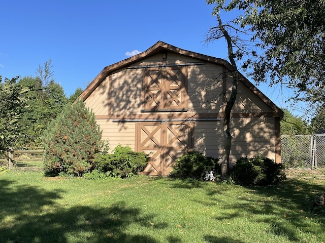 view of home's exterior with a lawn and an outdoor structure