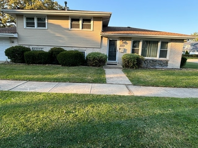 split level home featuring a front lawn