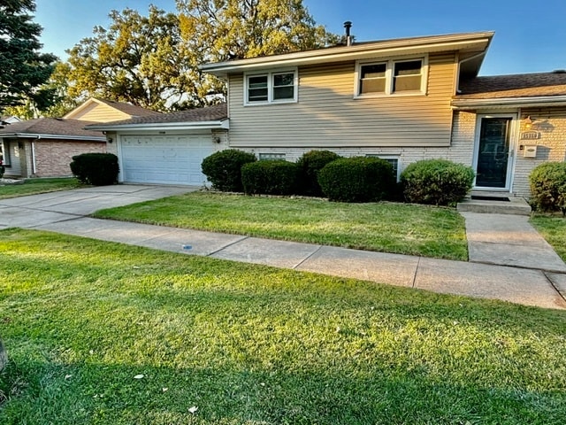 split level home with a garage and a front yard