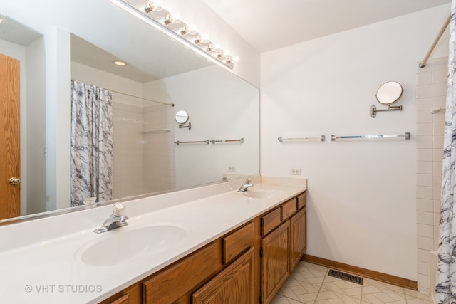 bathroom with a shower with curtain, vanity, and tile patterned floors