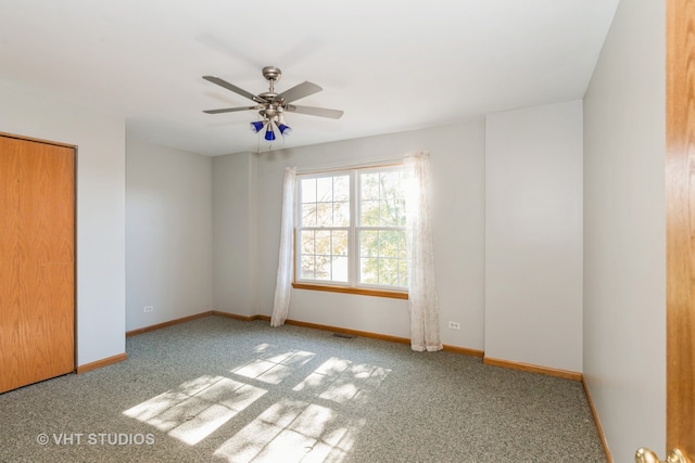 carpeted spare room with ceiling fan