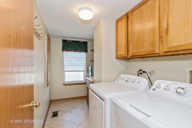 laundry area with light tile patterned flooring, independent washer and dryer, and cabinets