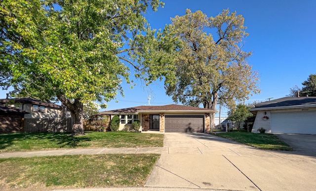 ranch-style house featuring a front yard and a garage