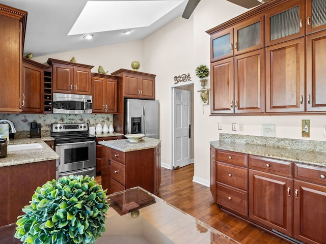 kitchen featuring dark hardwood / wood-style floors, sink, vaulted ceiling, stainless steel appliances, and backsplash