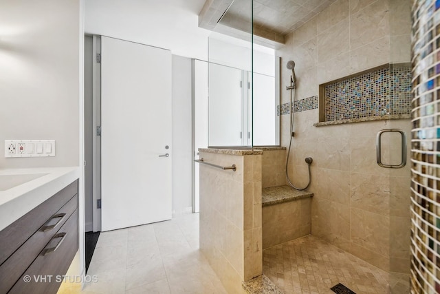 bathroom with vanity and a tile shower