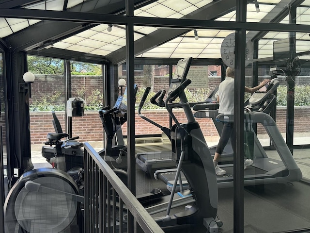 exercise room with expansive windows and brick wall