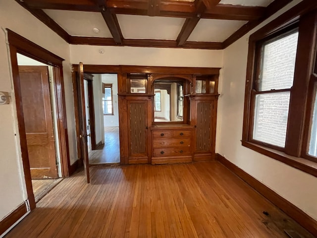 foyer entrance with coffered ceiling, beamed ceiling, and light hardwood / wood-style flooring