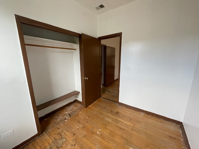 unfurnished bedroom with hardwood / wood-style floors and a closet