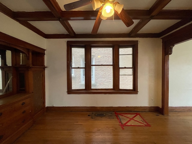 empty room with beamed ceiling, ceiling fan, coffered ceiling, and hardwood / wood-style flooring