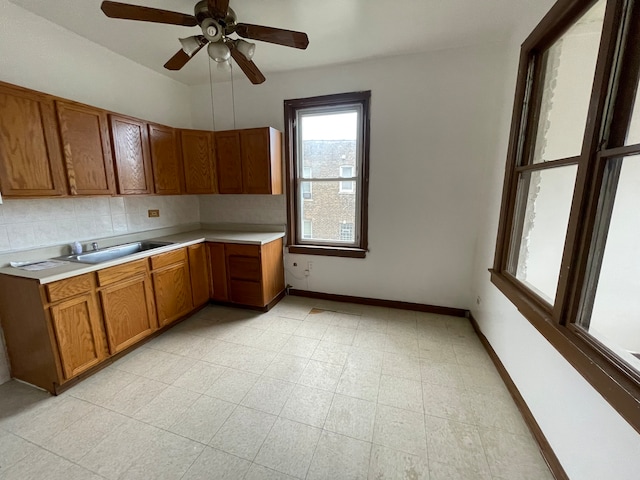 kitchen with decorative backsplash, sink, and ceiling fan