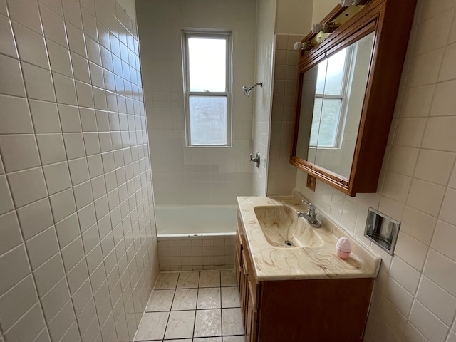 bathroom featuring tile walls, vanity, tiled shower / bath combo, and tile patterned floors