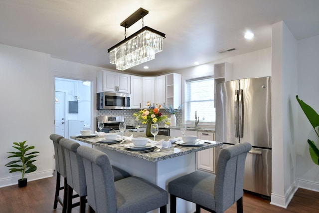 dining space with sink, an inviting chandelier, and dark hardwood / wood-style flooring