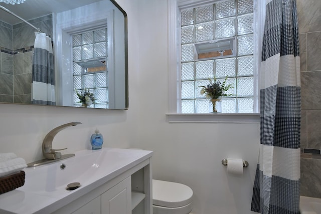 bathroom featuring vanity, toilet, and a shower with curtain