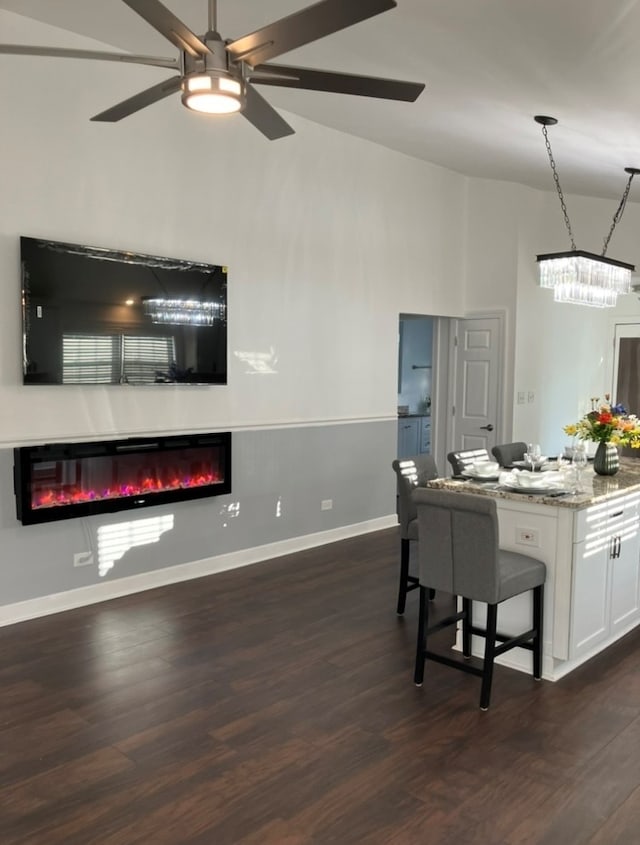 dining space featuring dark wood-type flooring, ceiling fan, and vaulted ceiling