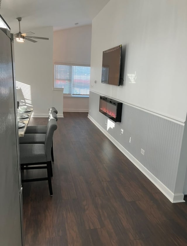 living room with dark wood-type flooring and ceiling fan