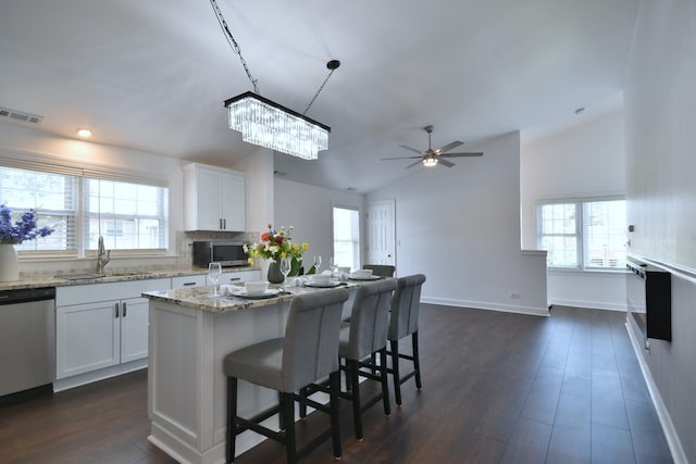 kitchen featuring appliances with stainless steel finishes, sink, white cabinets, a center island, and light stone countertops