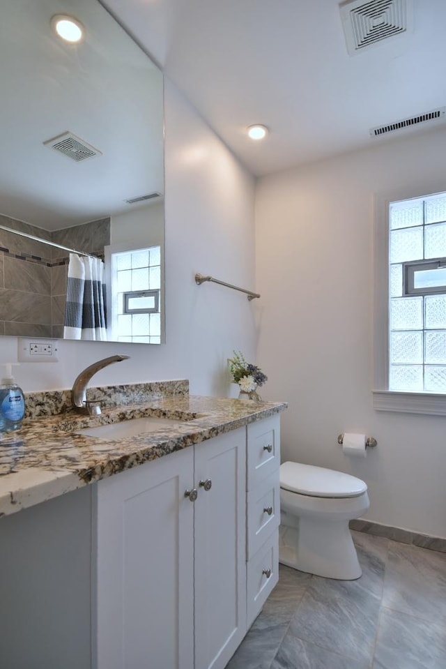 bathroom featuring a shower with curtain, vanity, and toilet