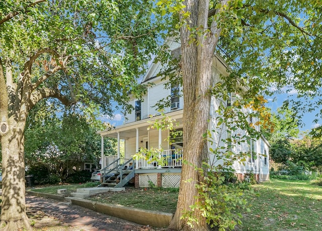 exterior space with covered porch and a yard