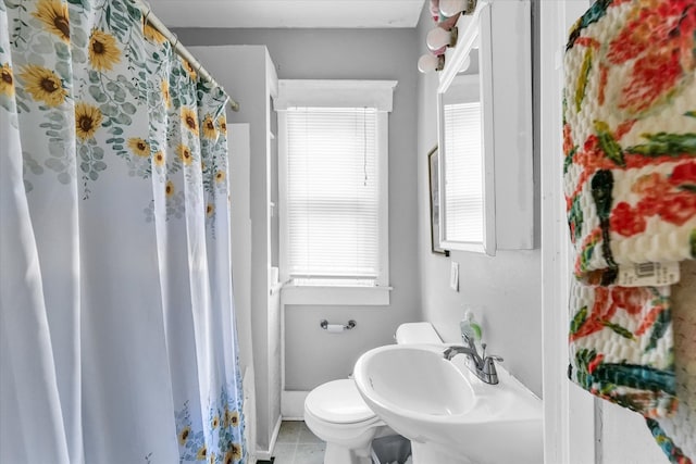 bathroom with toilet, curtained shower, sink, and tile patterned flooring