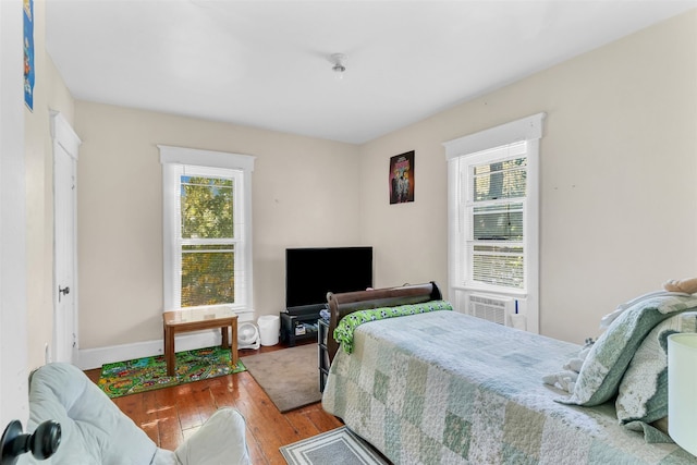 bedroom with cooling unit and hardwood / wood-style floors