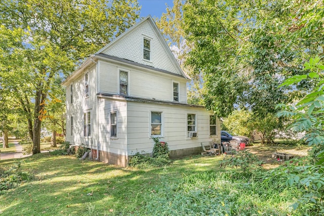 rear view of property with cooling unit and a lawn