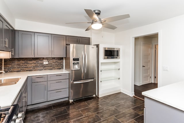 kitchen with ceiling fan, gray cabinetry, stainless steel appliances, and tasteful backsplash