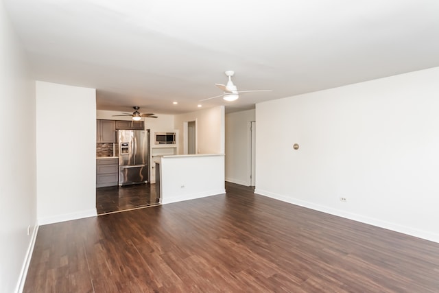 unfurnished living room with dark wood-type flooring and ceiling fan