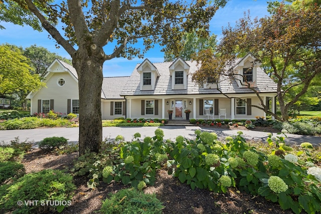 cape cod-style house featuring covered porch