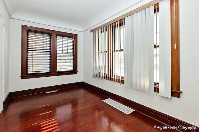 empty room featuring hardwood / wood-style floors and crown molding