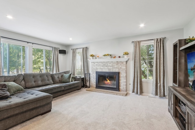 carpeted living room with a brick fireplace