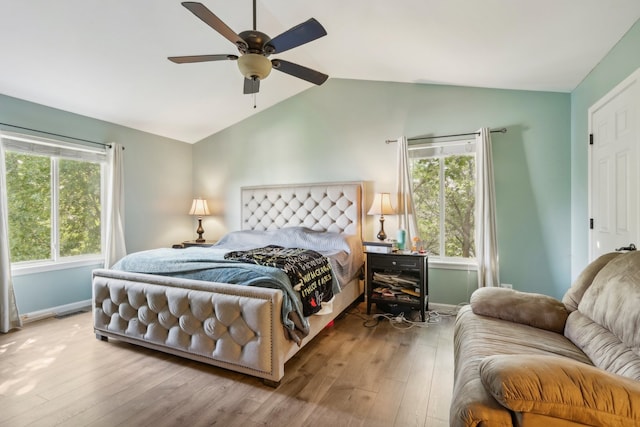 bedroom featuring ceiling fan, wood-type flooring, vaulted ceiling, and multiple windows