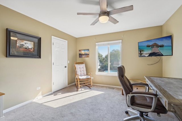 carpeted office space featuring ceiling fan