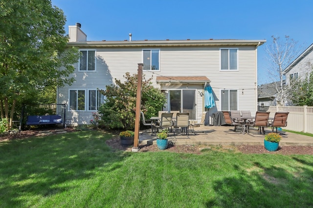 rear view of house featuring a lawn and a patio