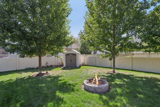 view of yard featuring a storage shed and an outdoor fire pit