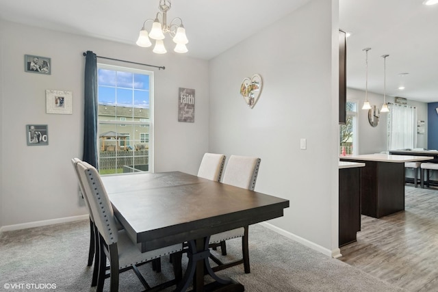 dining room with light hardwood / wood-style flooring and a notable chandelier