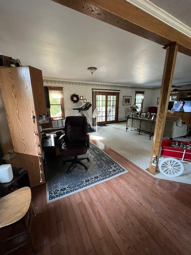 living room with beam ceiling, crown molding, and a tiled fireplace