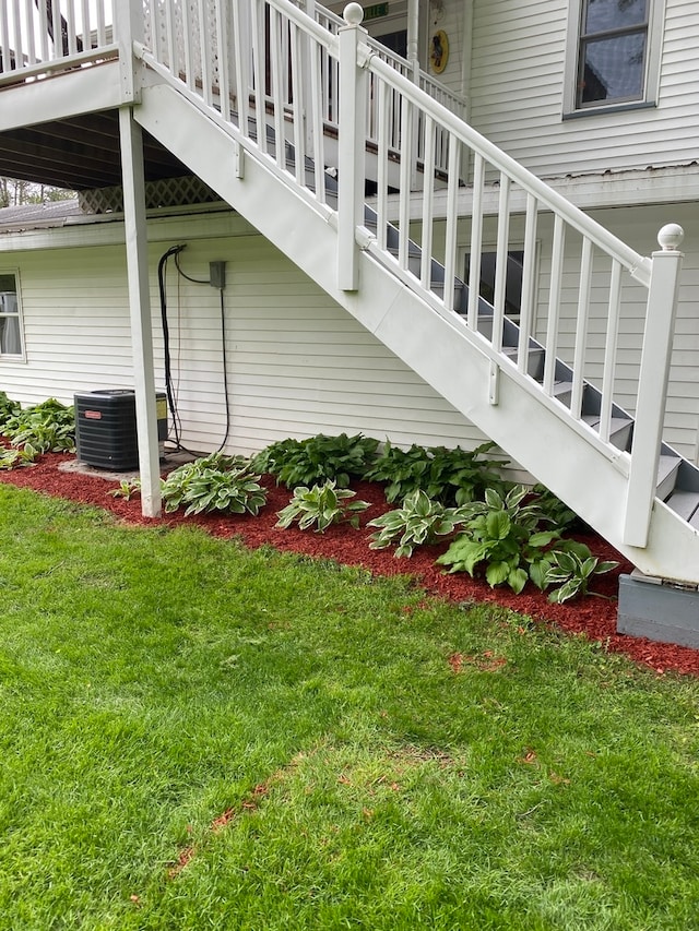 view of side of home featuring a yard and central AC