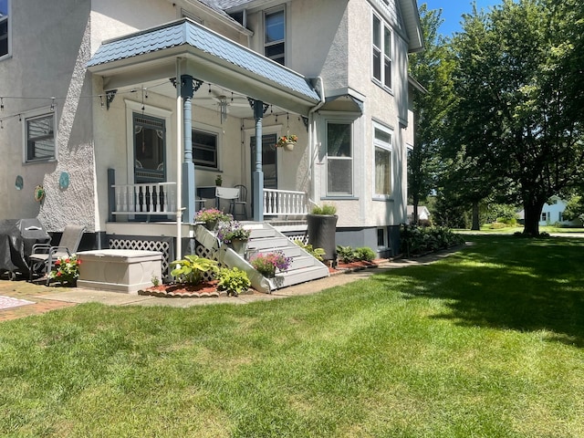 entrance to property featuring a yard and a porch