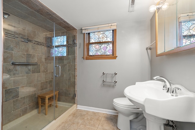 bathroom with walk in shower, tile patterned flooring, toilet, and sink