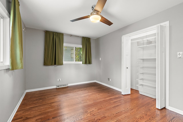 unfurnished bedroom featuring ceiling fan, a closet, and hardwood / wood-style flooring