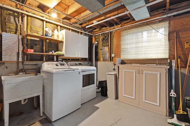 laundry room featuring washing machine and clothes dryer and cabinets