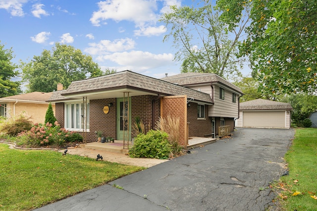 view of front of house featuring a front yard, a garage, and an outbuilding