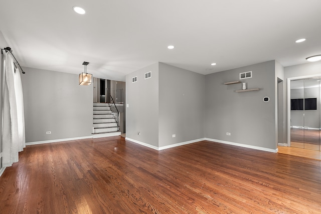 spare room with dark wood-type flooring and a barn door